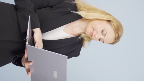 Vertical-video-of-Business-woman-looking-at-laptop-with-tired-expression.